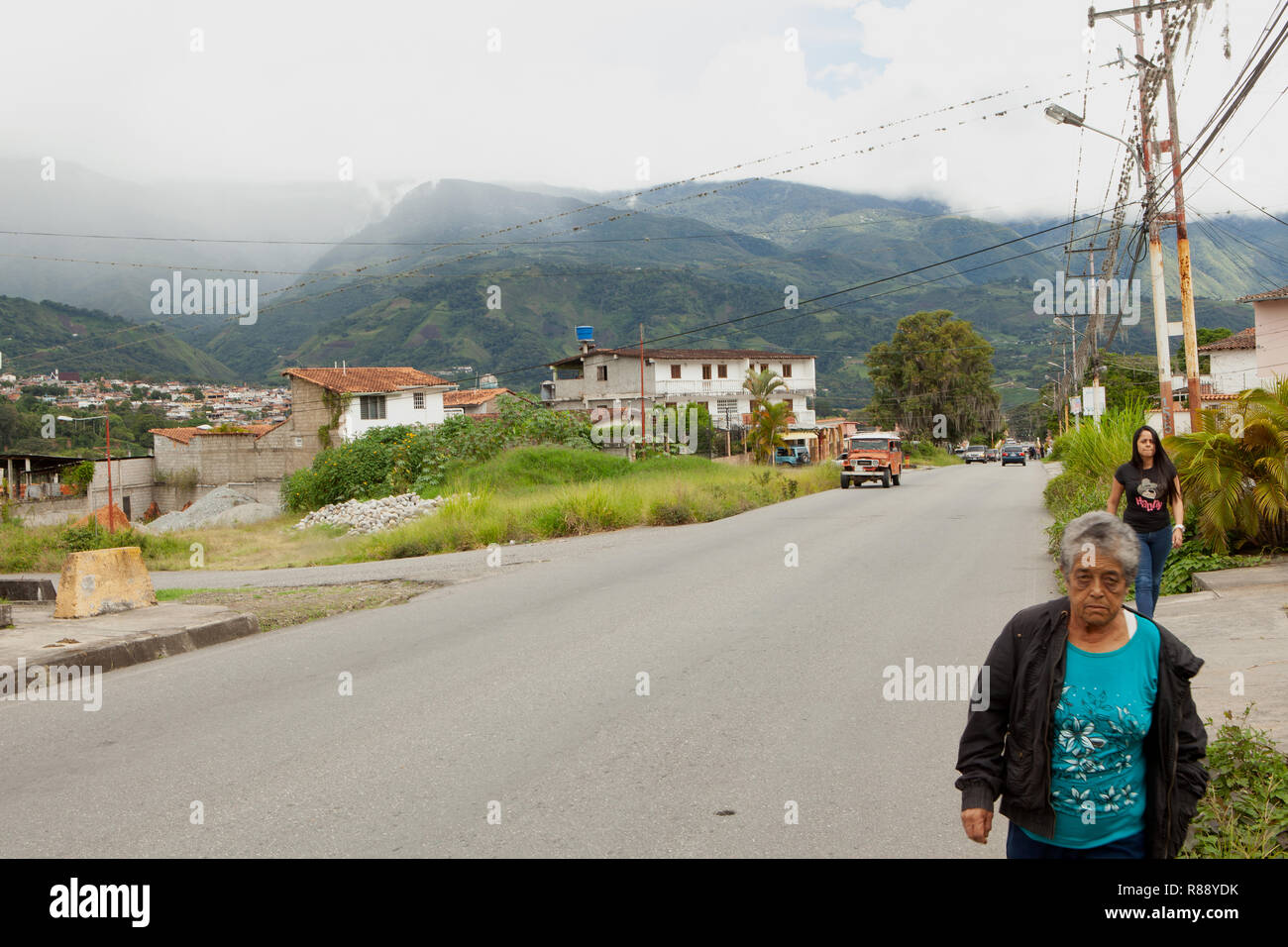 Two women walking along suburban roadside, Merida, Venezuela, South America Stock Photo