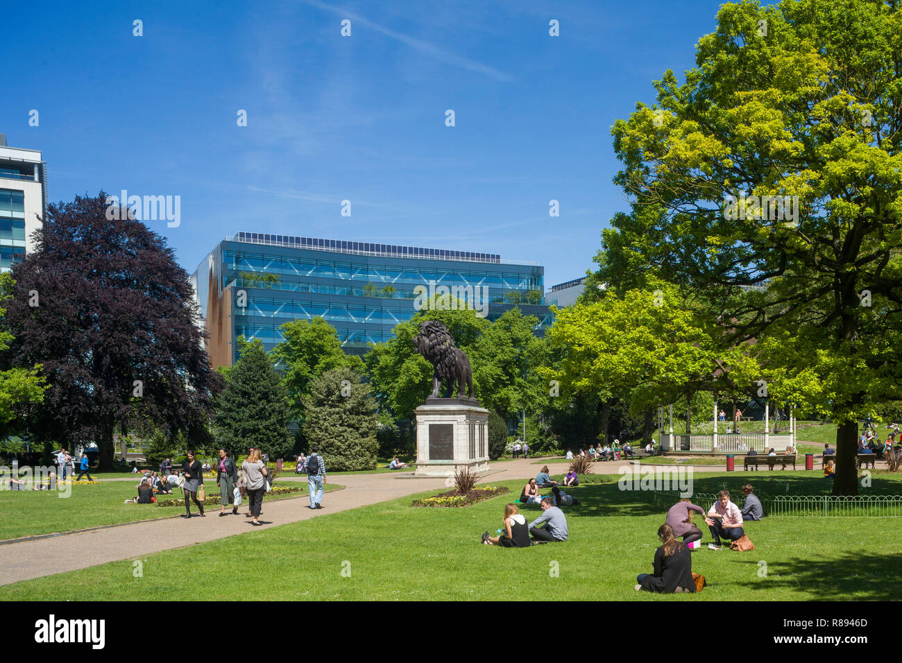 People enjoy the sun at lunchtime in Forbury Gardens, Reading, Berkshire Stock Photo
