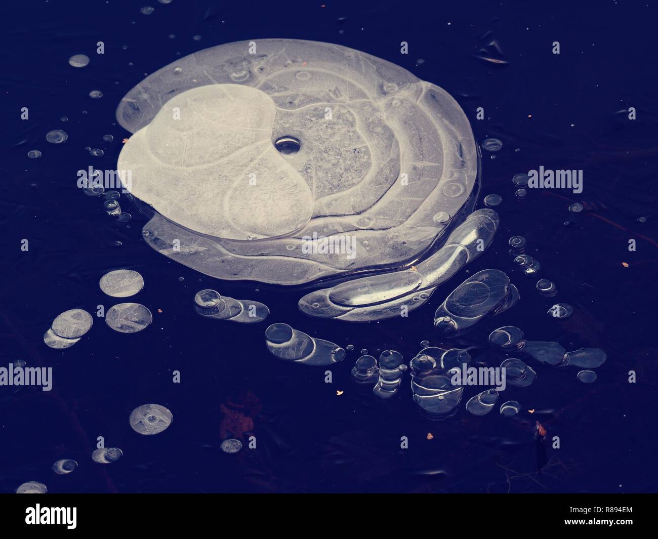 Nice ice hole in lake ice, natural art. Amazing shapes from air bubbles ...