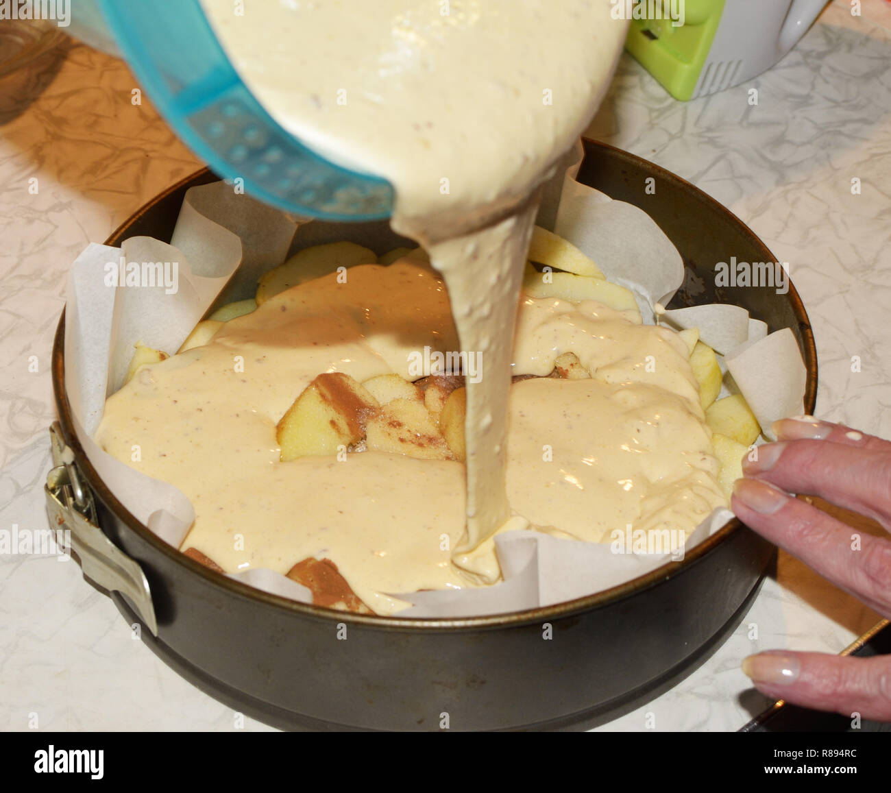 Pouring the dough into a metal mold.It will bake a cake in the oven gas