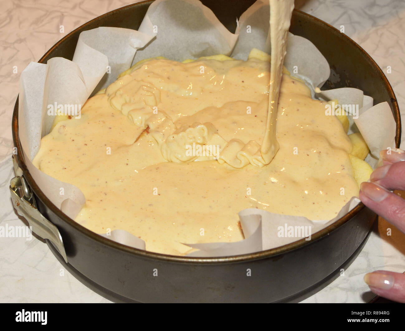 Pouring the dough into a metal mold.It will bake a cake in the oven gas