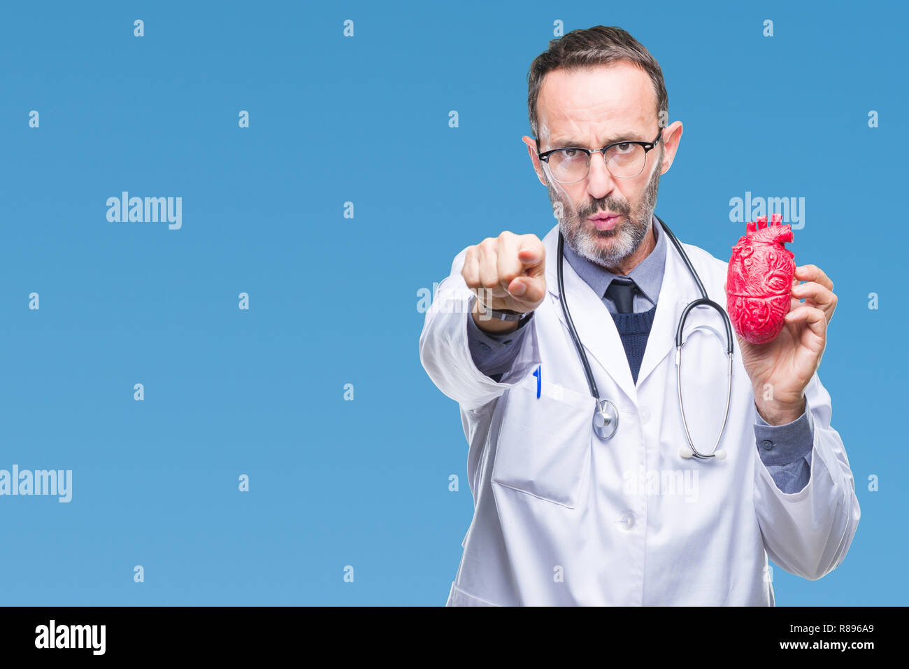 Middle age senior hoary cardiologist doctor man holding heart over ...