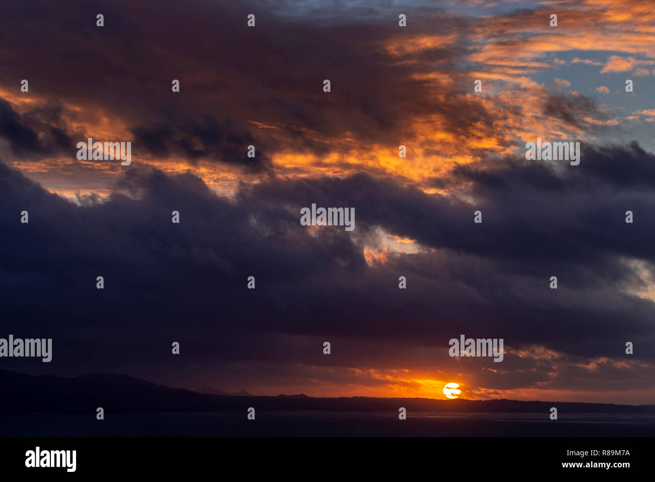 Sunset with clouds over the Irish Sea at Llandudno West Shore, North Wales Stock Photo