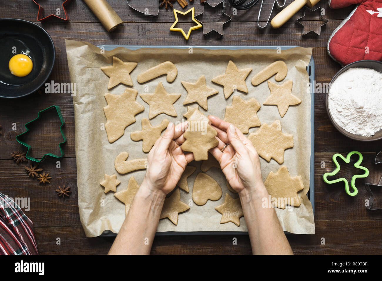 Homemade christmas cookies on parchment. Woman rolls dough. Xmas. The process of baking homemade cookies. Stock Photo