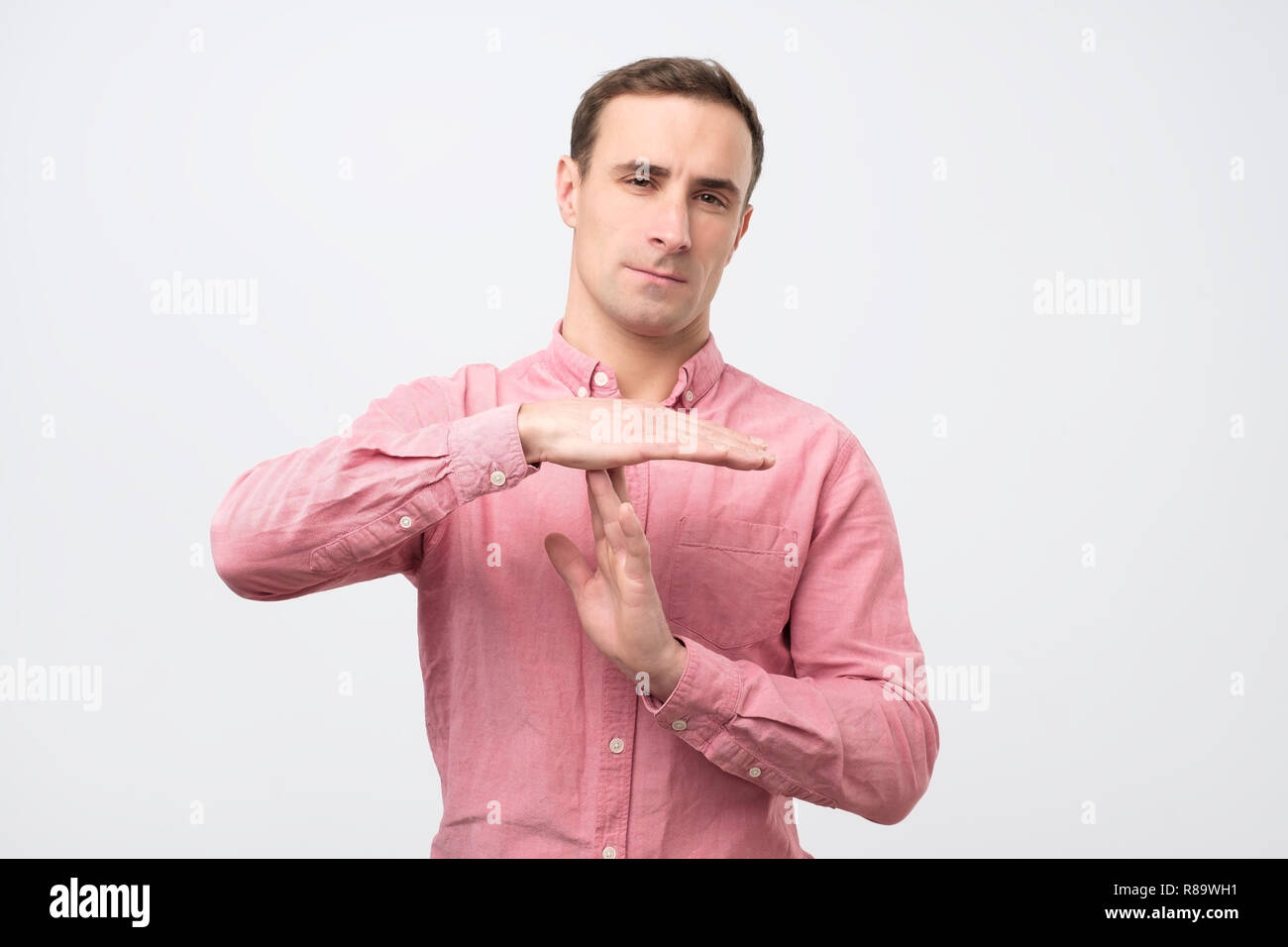 Young man giving showing time out hands gesture Stock Photo - Alamy