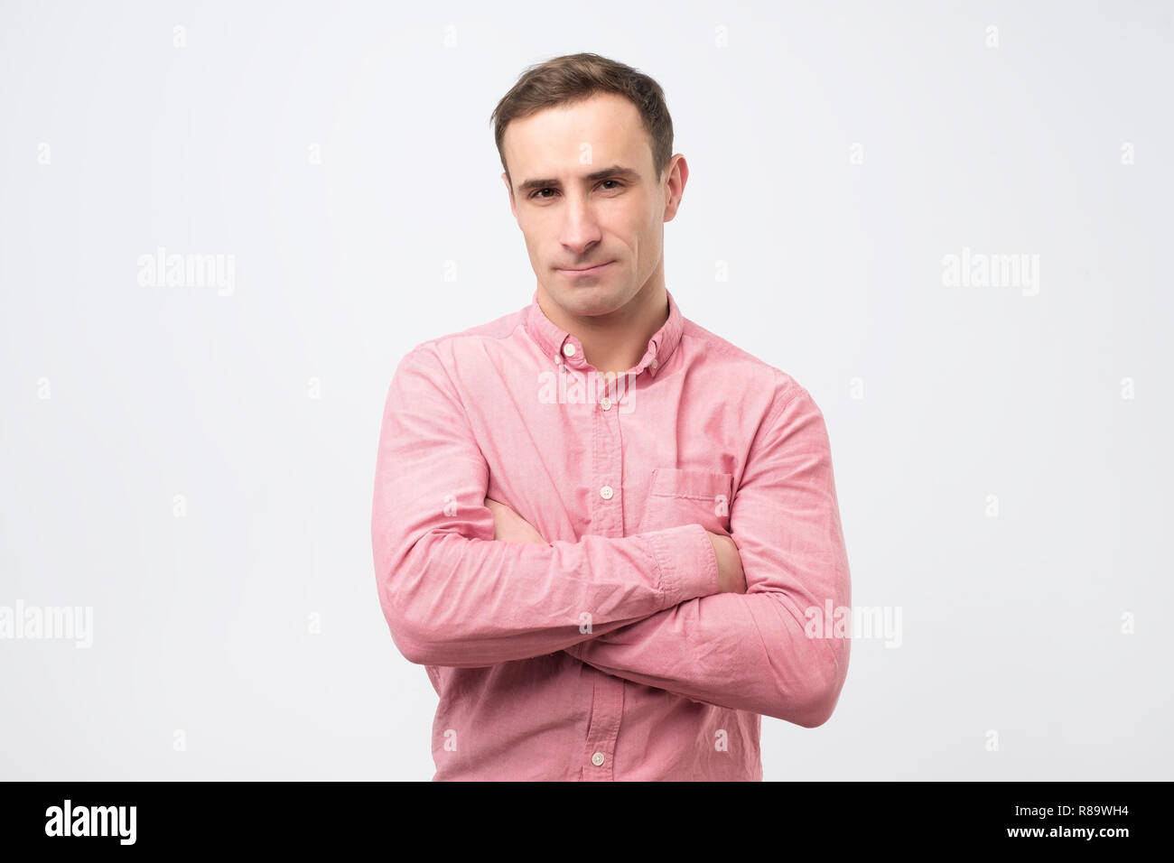 Sad unhappy young man in pink shirt has grumpy expression after quarrel with wife. Stock Photo