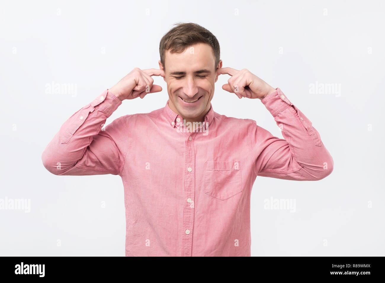 Cheerful italian man plugging ears with fingers and winking. Stock Photo