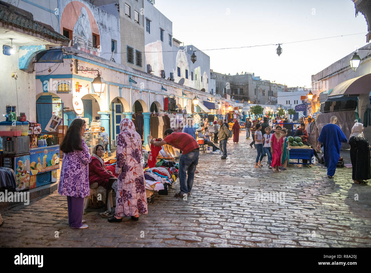 Colorfully Lit Street with Storefronts, Larache, Morocco Stock Photo