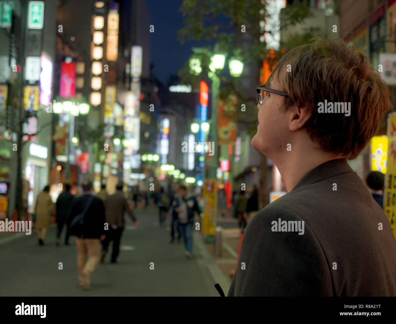 A young man exploring the neon lights of a big Asian city Stock Photo