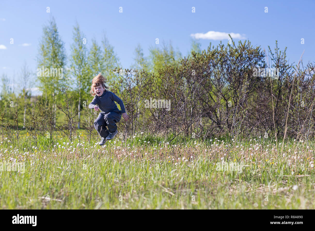 Happy and cheerful child jumping in a summer park Stock Photo - Alamy