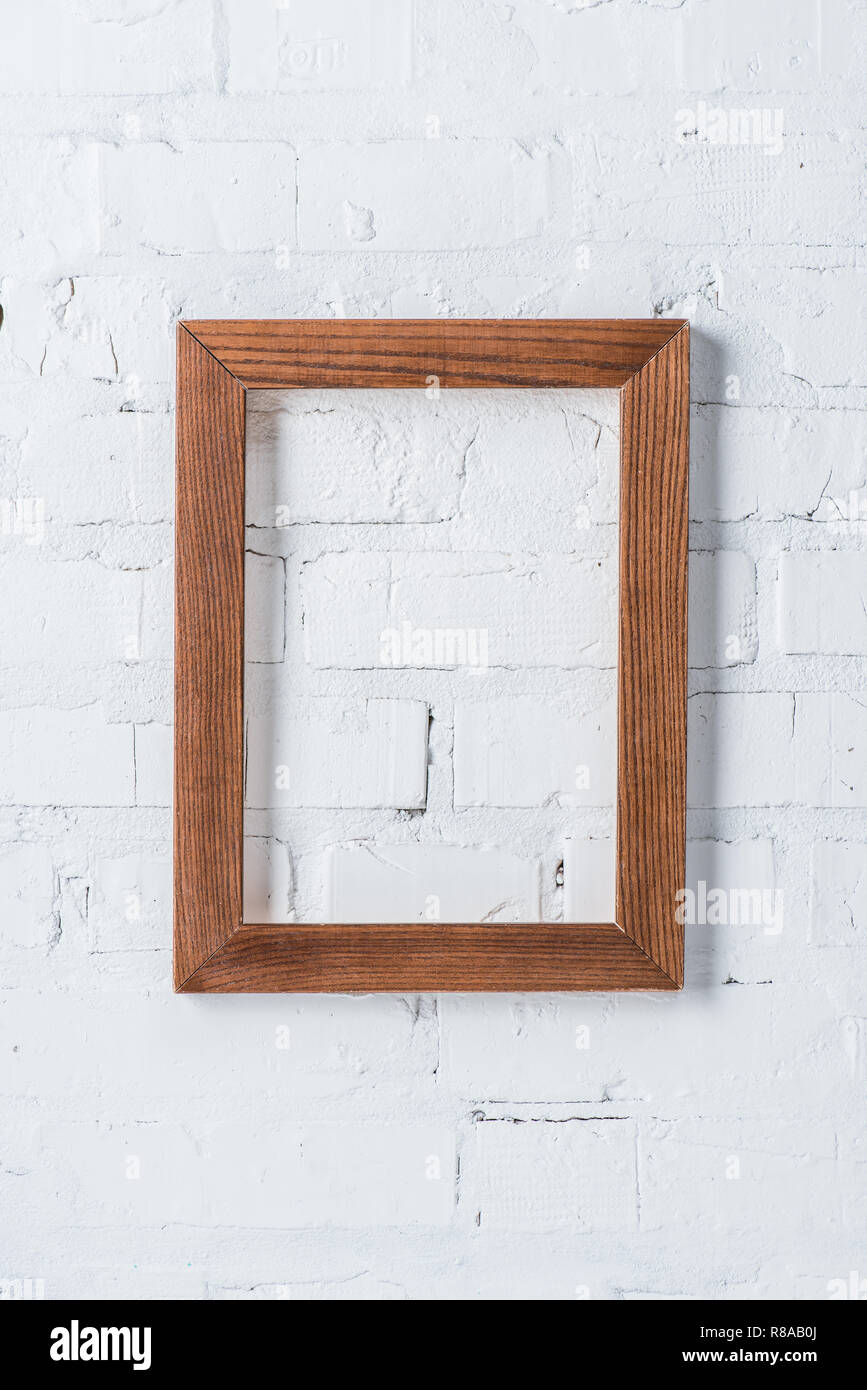 brown empty frame hanging on white brick wall Stock Photo - Alamy