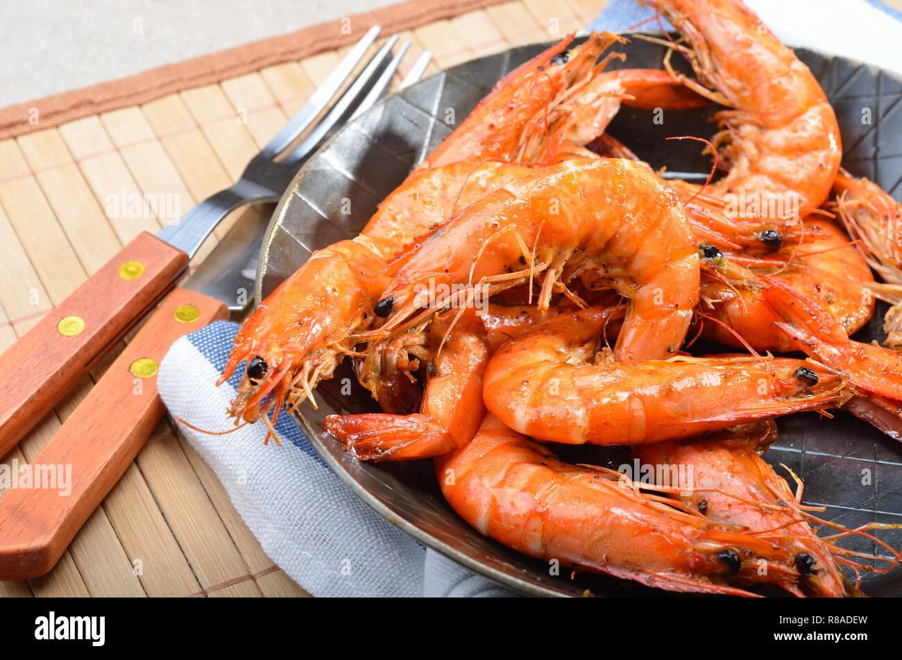 Fried king prawns in an iron serving pan Stock Photo Alamy