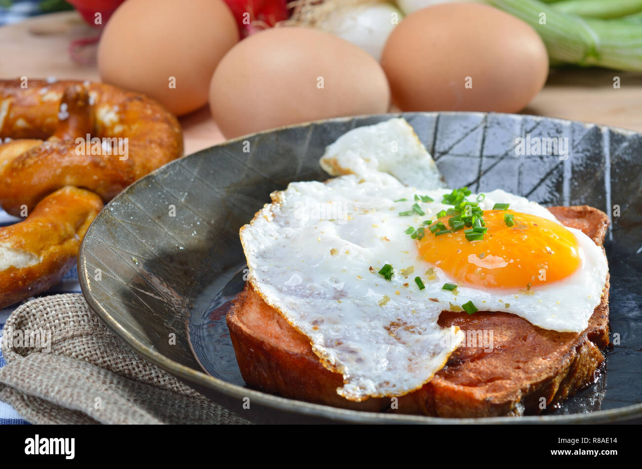 Fried meat loaf with an egg sunny side up in an iron pan Stock Photo