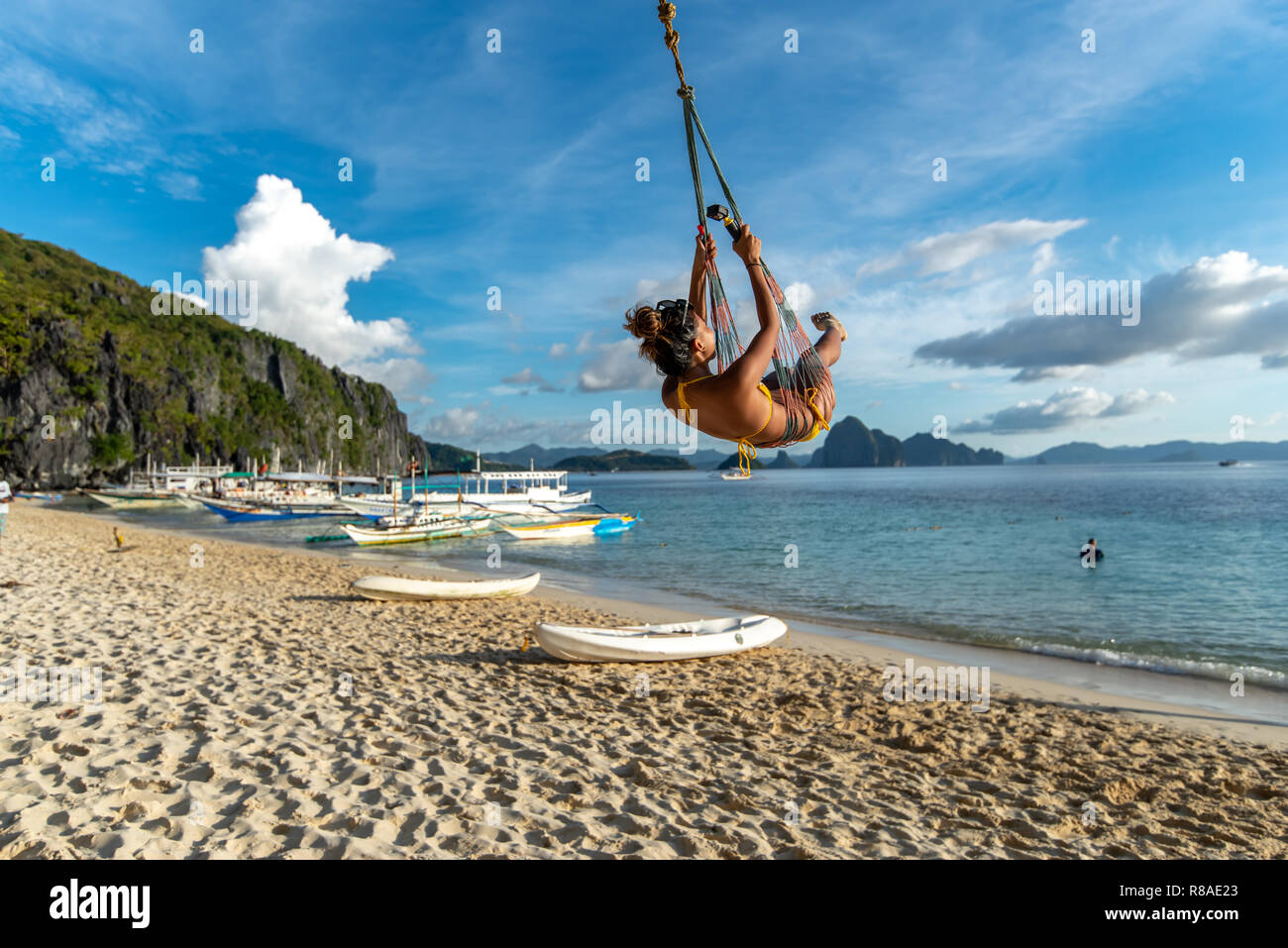 A woman on a swing at the 7 Commandos island beach, El nido, Palawan