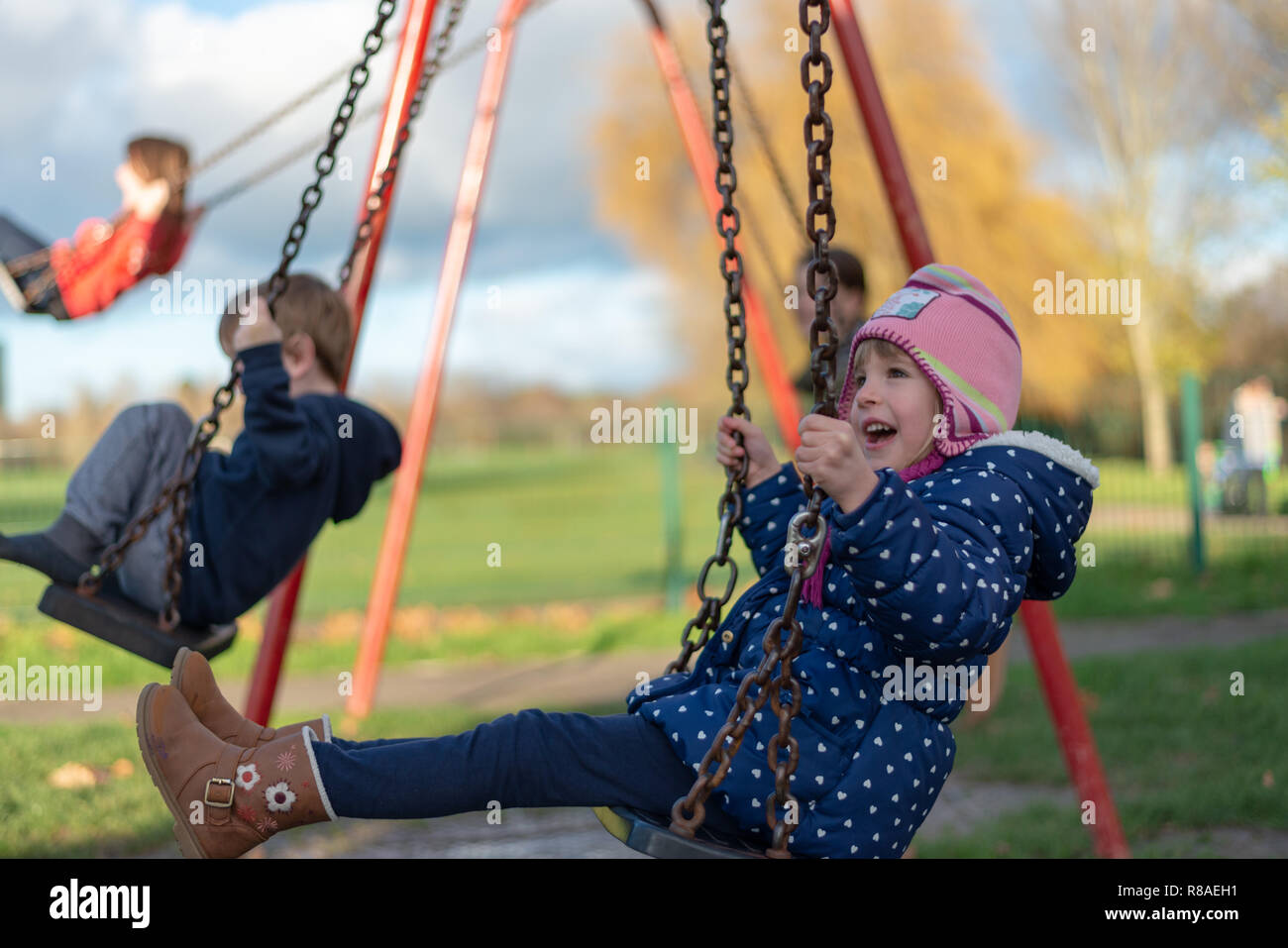 Pre-school aged caucasian female in the playground on the swing Stock Photo