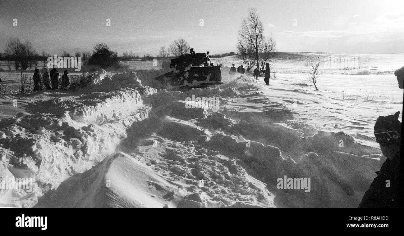 A snowplow makes its way through meter-high snow mountains on the highway Neubrandenburg-Altentreptow was nothing more. Even the Soviet tanks, which rushed to the aid of the Neustrelitz garrison, often remained stuck in the snow. The winter of 1978/79 brought large parts of the country to a standstill. - DISABLED FOR BILDFUNK - | usage worldwide Stock Photo