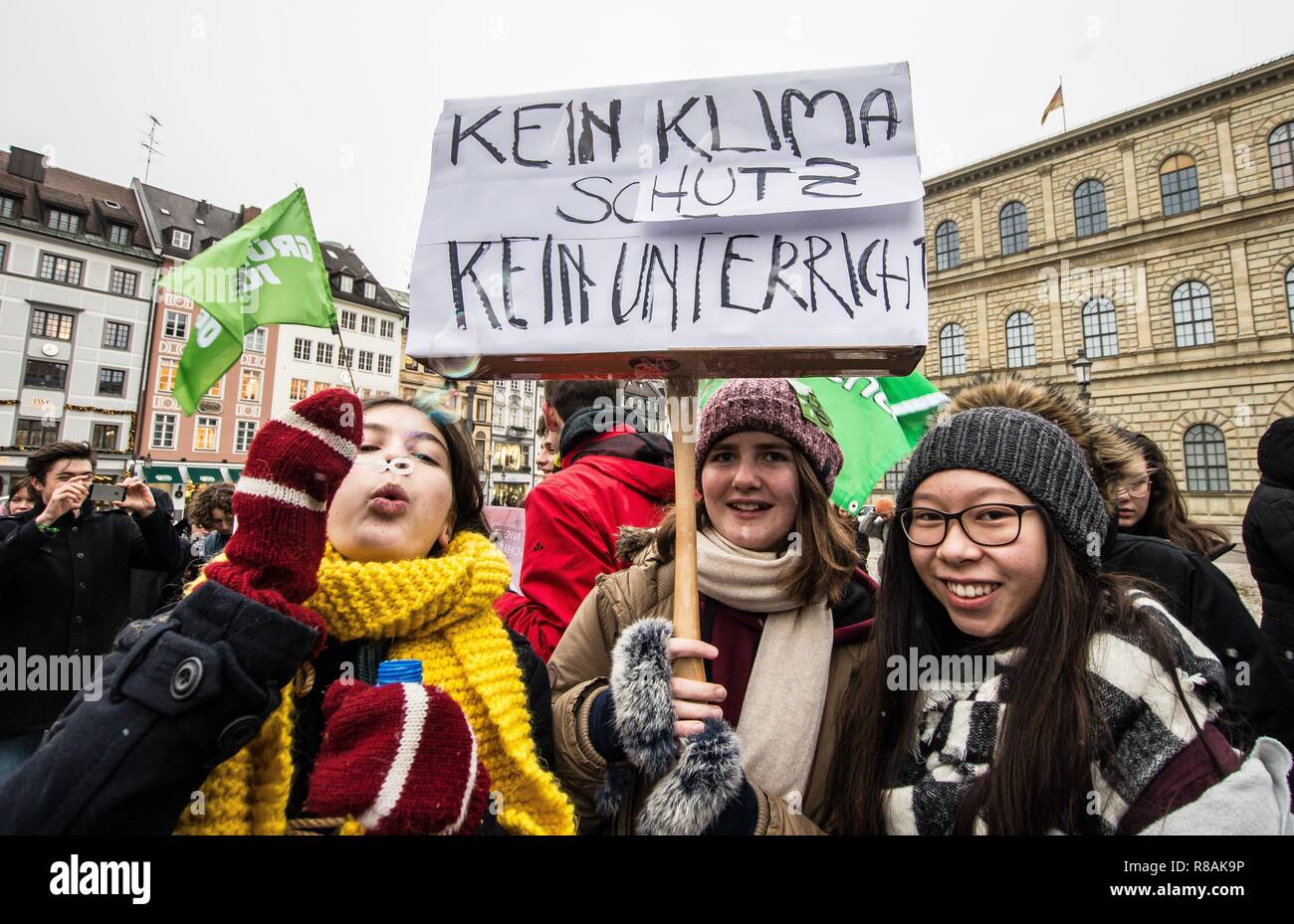 Munich, Bavaria, Germany. 14th Dec, 2018. ''No climate protection, no lectures'' displayed by three students on strike in Munich, Germany. As part of a worldwide action, 100 students and concerned citizens participated in a climate strike at Munich's Max Joseph Platz. The protestors are calling on world governments to take decisive action against climate change. The demonstration ended with an artistic action where the participants used chalk to color the ground with environmental designs and slogans. One of the designs was a crossed out swastika, signifying the group's stance agai Stock Photo