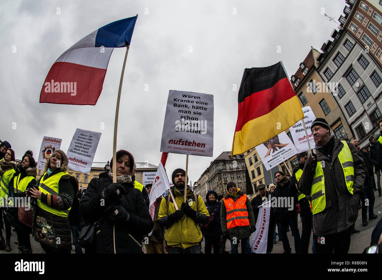 Munich, Bavaria, Germany. 15th Dec, 2018. Demonstrators at a Yellow Vests  rally in Munich, Germany wave French and German flags together. In an  attempt to bring the revolutionary Gilets Jaunes movement from