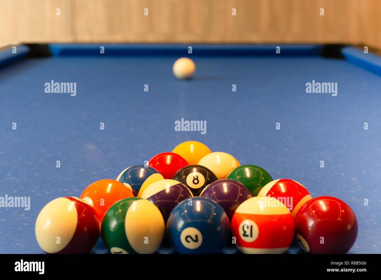 Multi Colour billiard balls lie on the blue cloth table in the triangle