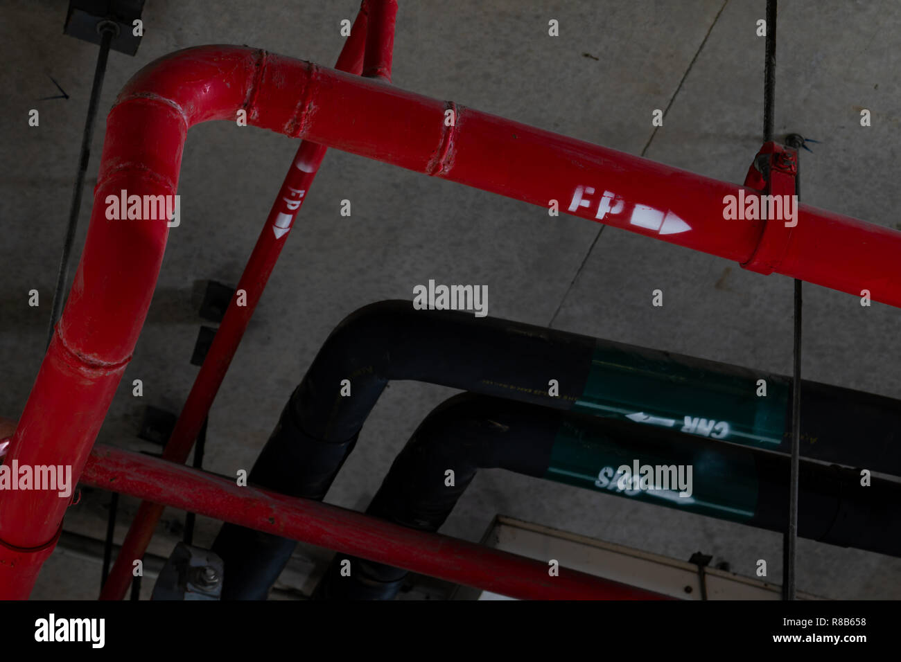 Fire sprinkler system with red pipes hanging from ceiling inside building. Fire Suppression. Fire protection and detector. Main supply water piping in Stock Photo