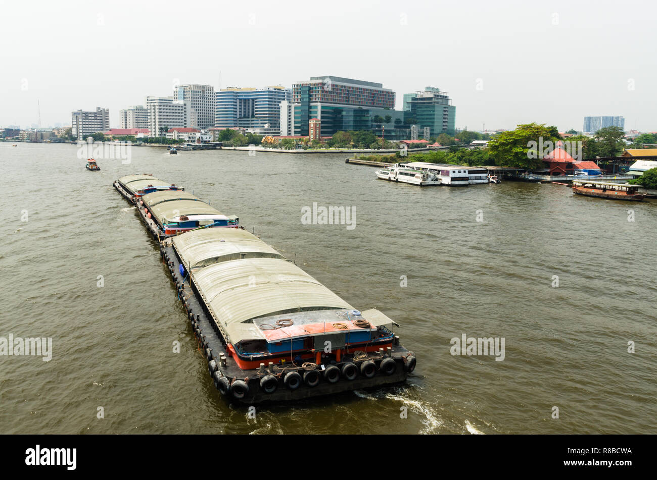 Tugboat towing a barge on Chao Phraya river, Bangkok, Thailand Stock Photo
