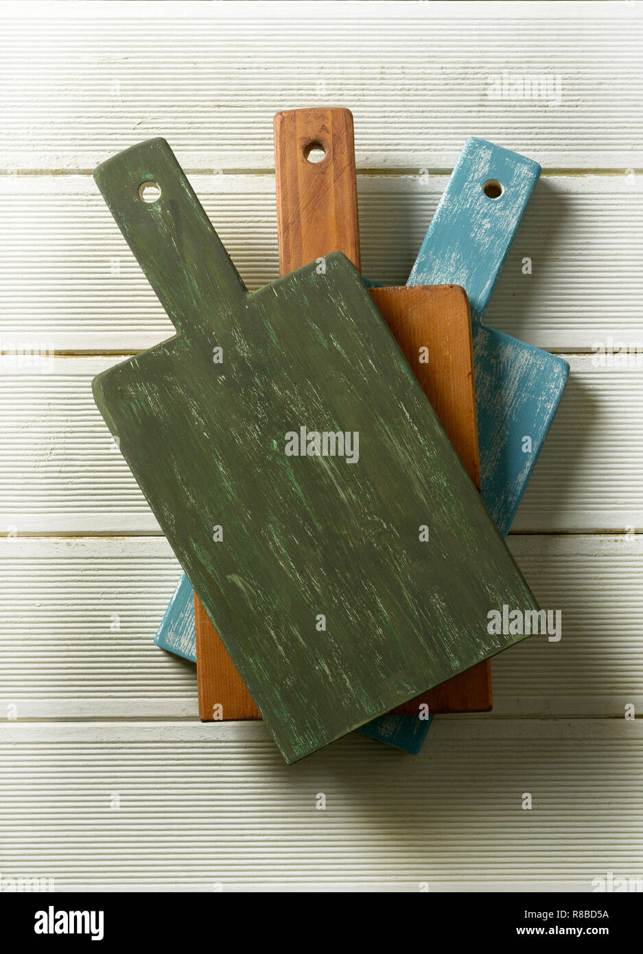 three colored cutting boards on white table - closeup Stock Photo
