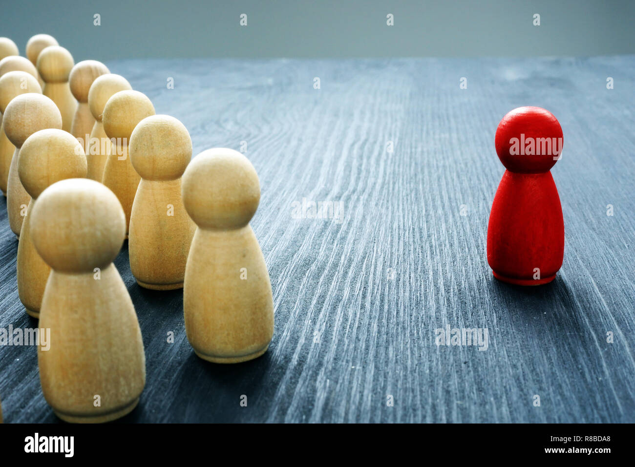 Leadership concept. Crowd of wooden figures and red one. Stock Photo