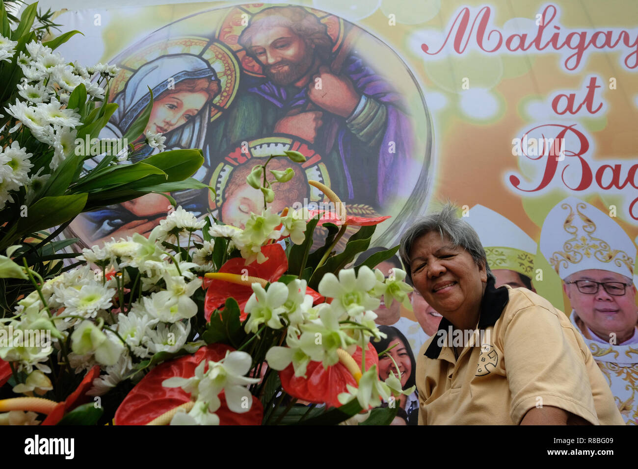 Filipino woman selling flowers in front of the Roman Catholic Antipolo Cathedral or National Shrine of Our Lady of Peace and Good Voyage located in the city of Antipolo, in the province of Rizal in the Philippines. Stock Photo