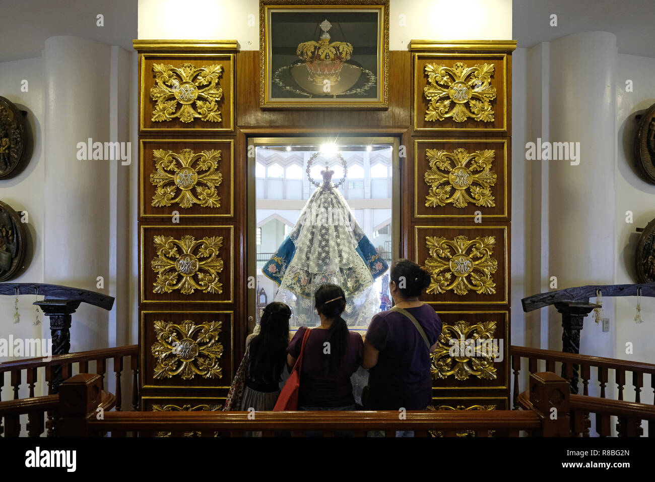 Filipino visitors praying in front of the 17thcentury statue of the