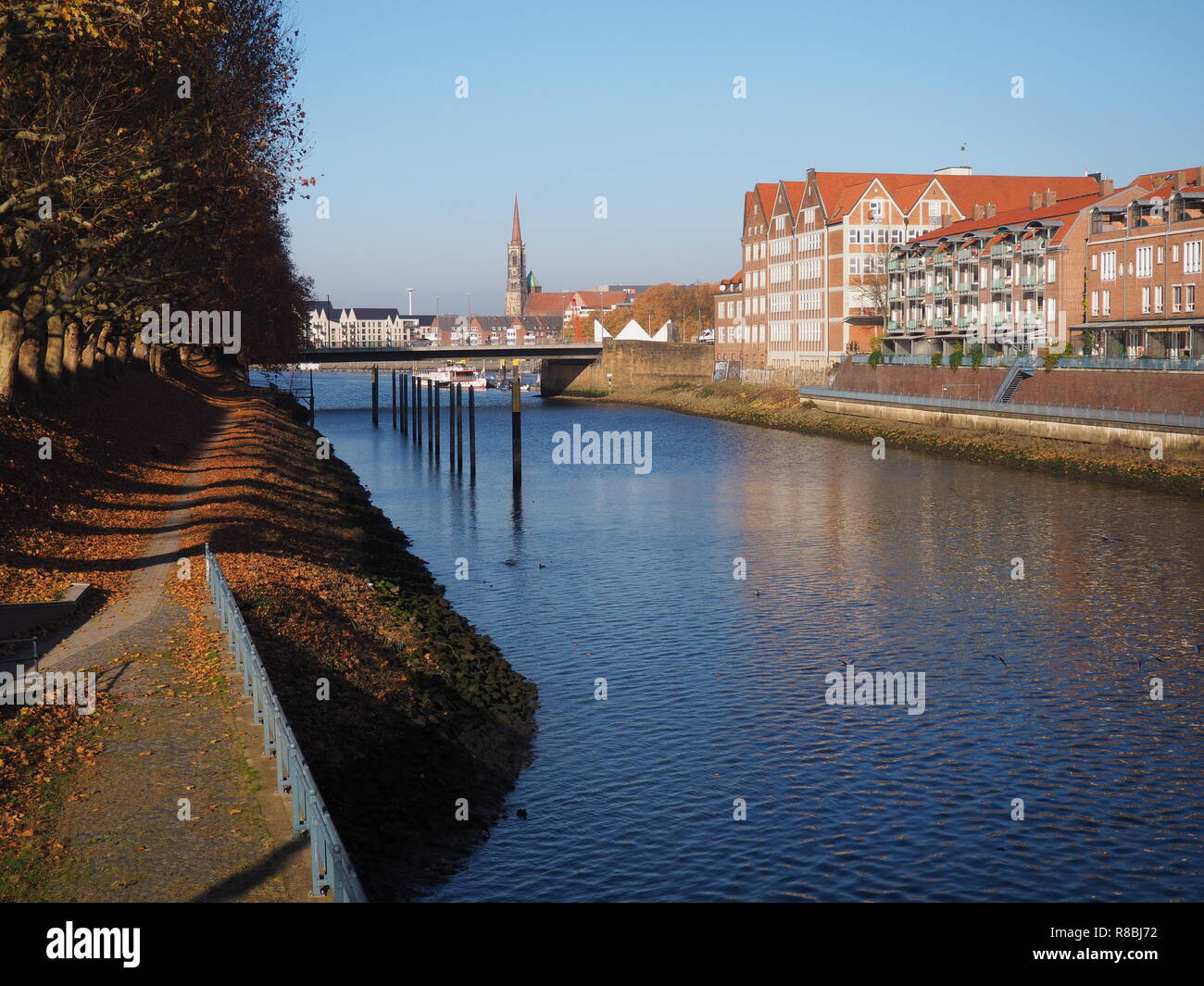 Bremen, Germany - View of the Werdersee lake and the historic brick buildings on the Teerhof peninsula towards the river Weser with the spire of St St Stock Photo