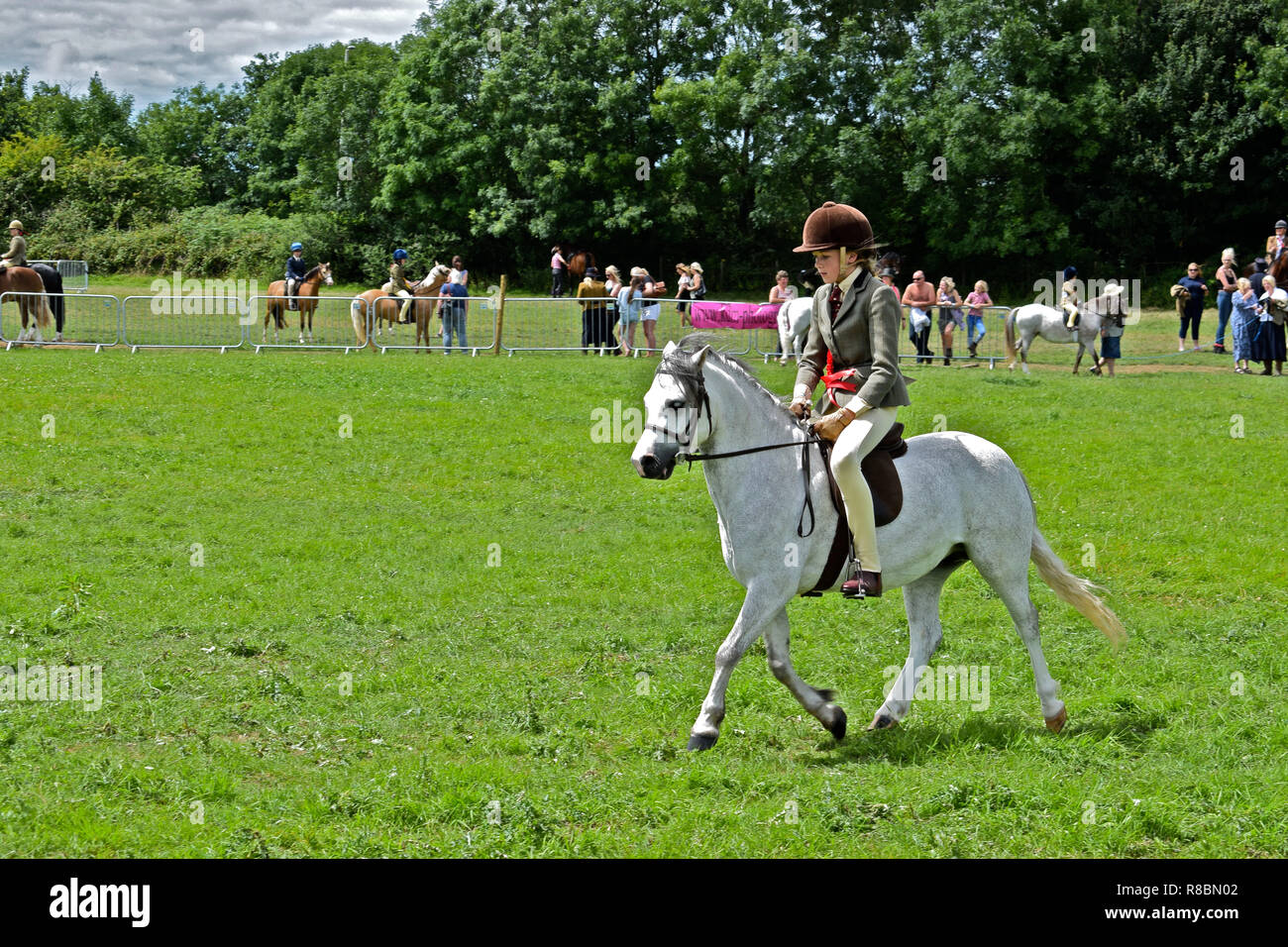 A young girl rides her pony in a traditional horse & rider competition