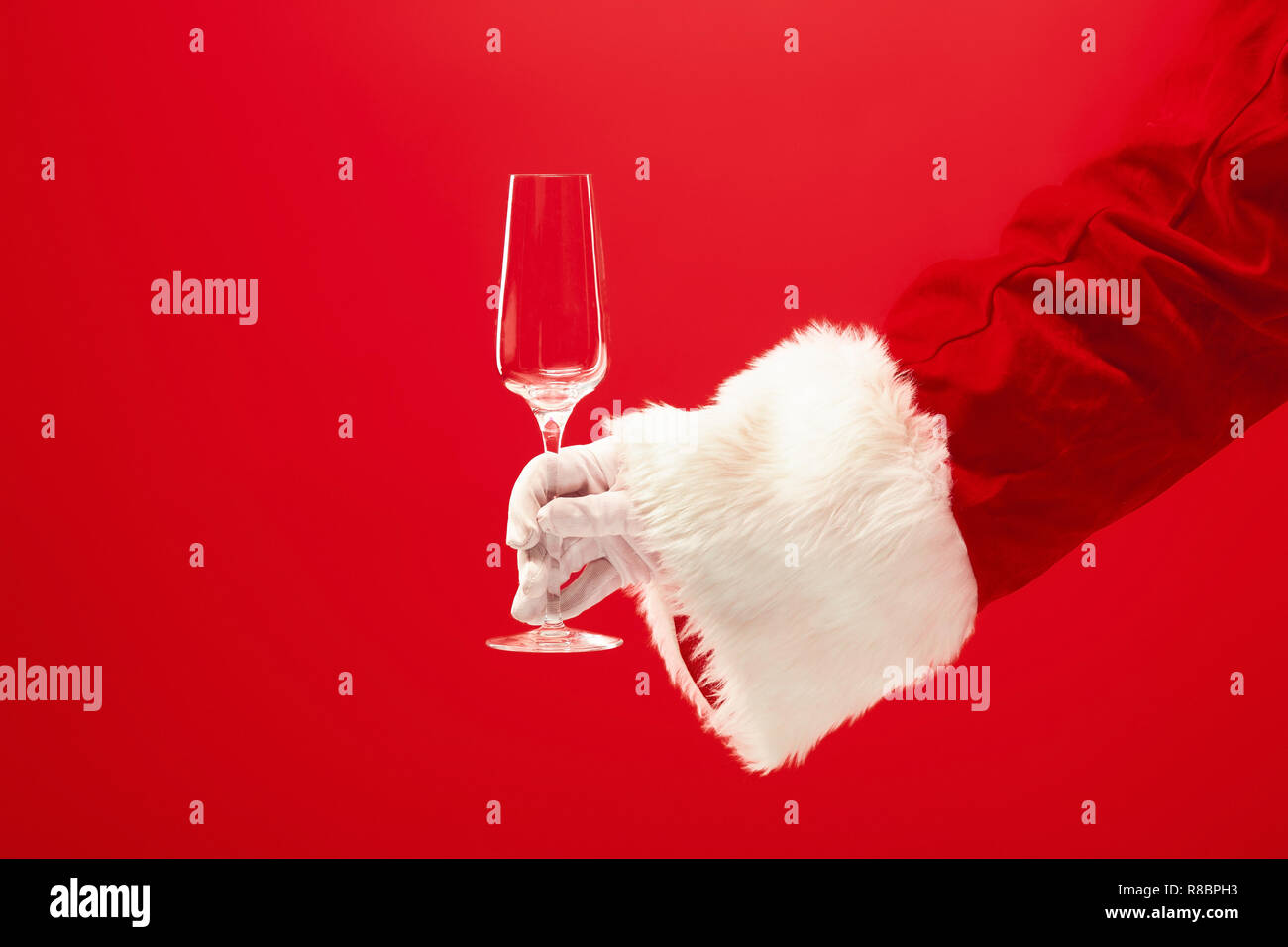 Santa Holding Champagne wineglass over red background. The season, winter, holiday, celebration, gift concept Stock Photo