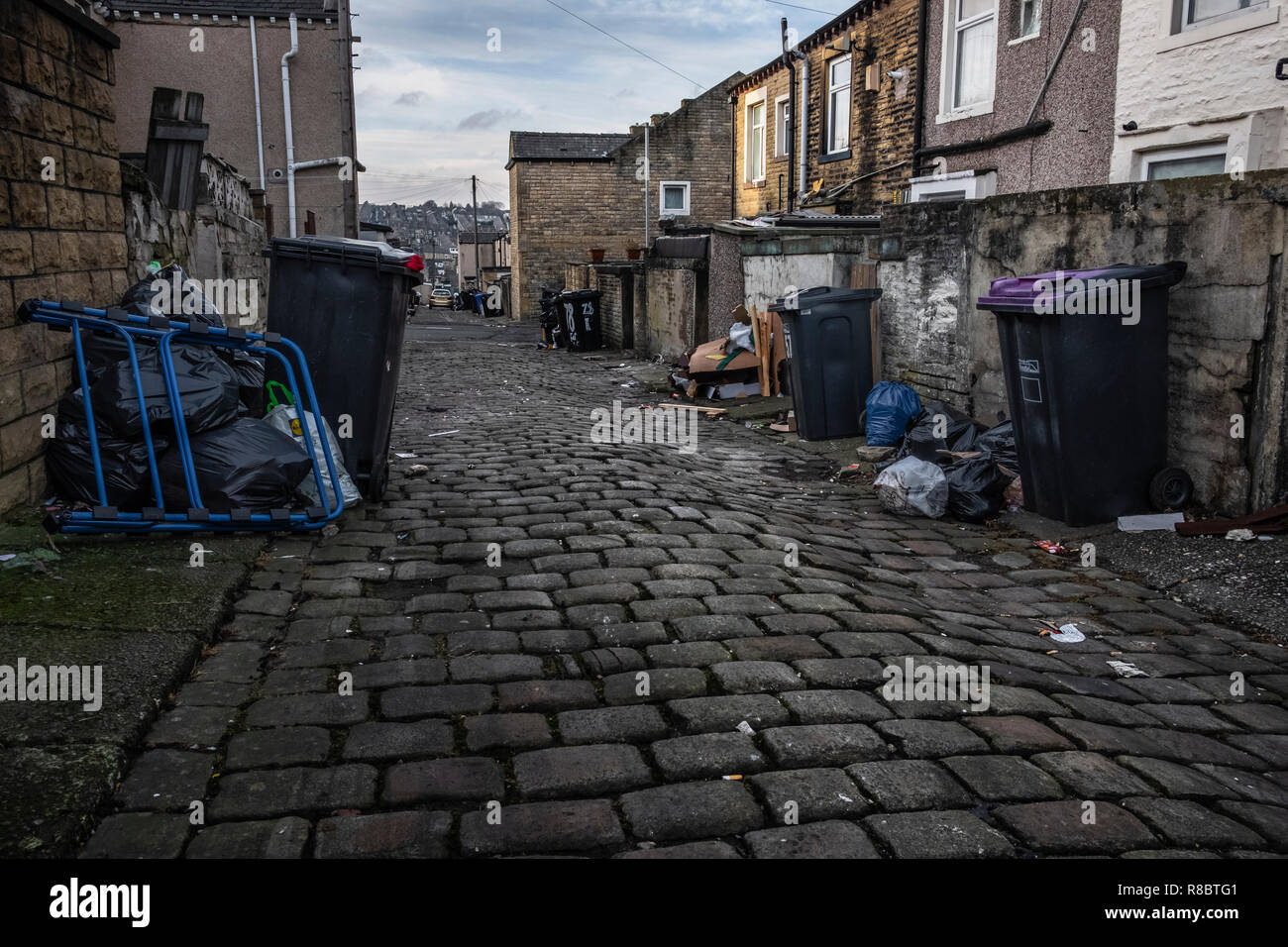 Wheelie bins and rubbish in a back alley in the former mill town of  Nelson, Lancashire Stock Photo