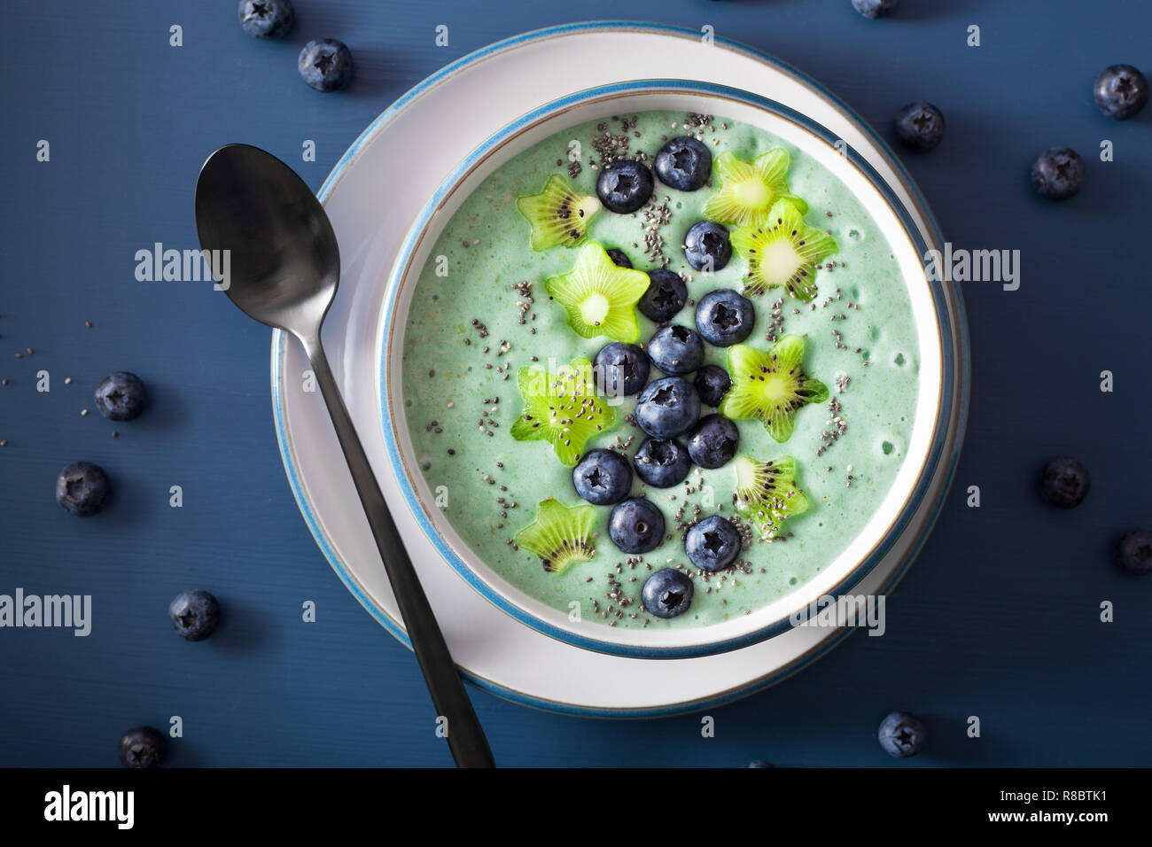 healthy spirulina smoothie bowl with blueberry, kiwi stars, chia seed