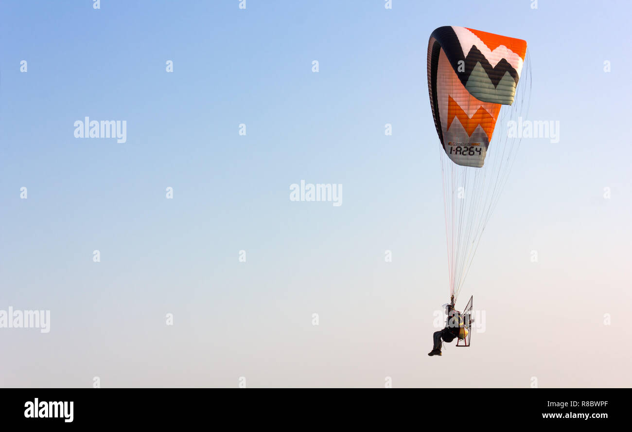 CAORLE, Italy - October 14, 2018: Powered paraglider flying in a clear sky Stock Photo