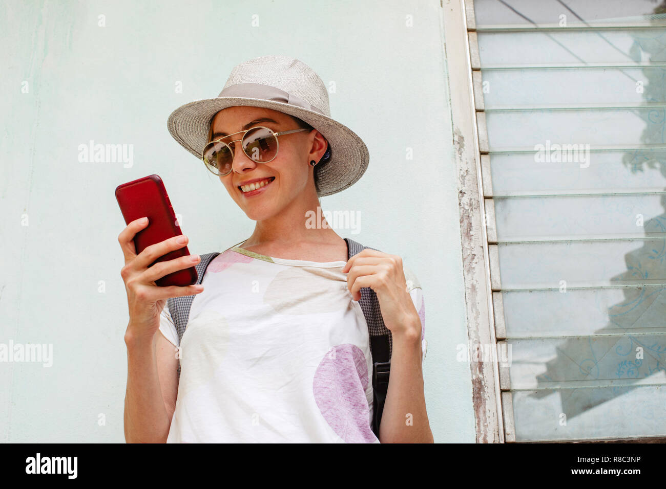 Stylish female using smartphone near shabby building Stock Photo