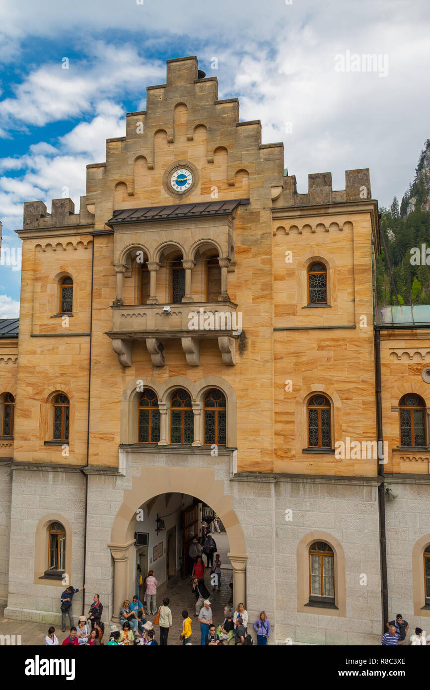 View of the Gatehouse, cased with yellow limestone, from inside of the famous Neuschwanstein Castle in Bavaria, Germany. Tourists are waiting at the... Stock Photo