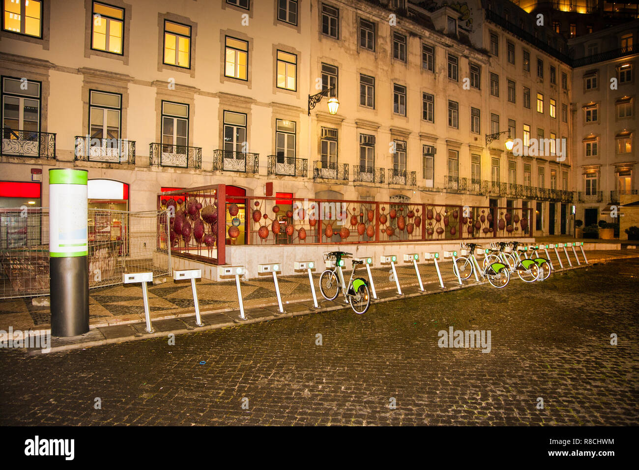 City bicycles by night .Alternative ecological public transport and lease of city bicycle. Lisbon, Portugal. Stock Photo