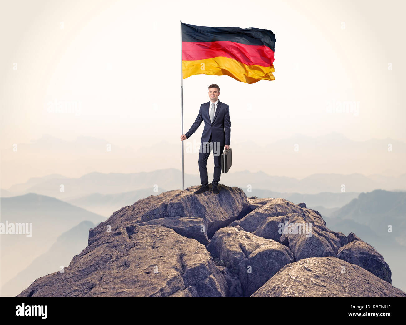 Successful businessman on the top of a mountain holding victory flag ...
