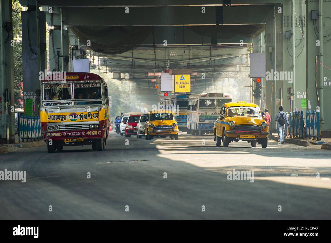 Some Ambassador cab taxi, buses and people through the streets of Kolkata. Stock Photo