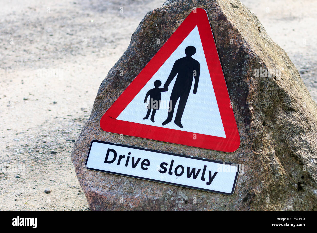 Pedestrians in road sign Drive slowly Stock Photo