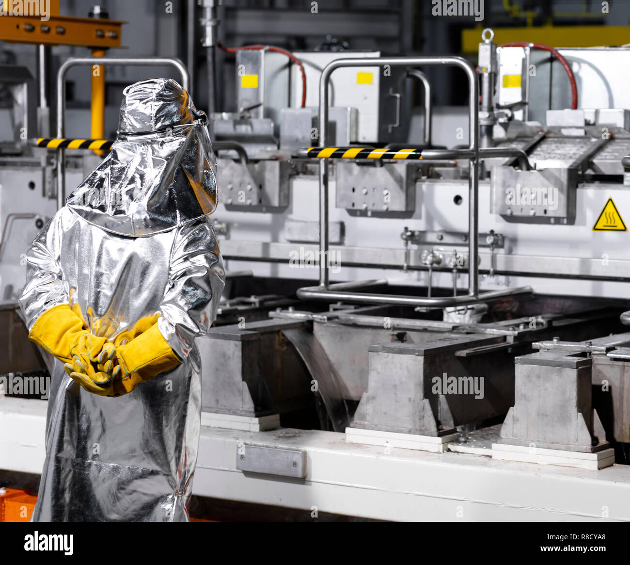 a worker with safety aluminized coat, yellow gloves and helmet controlling the cast. Photo taken