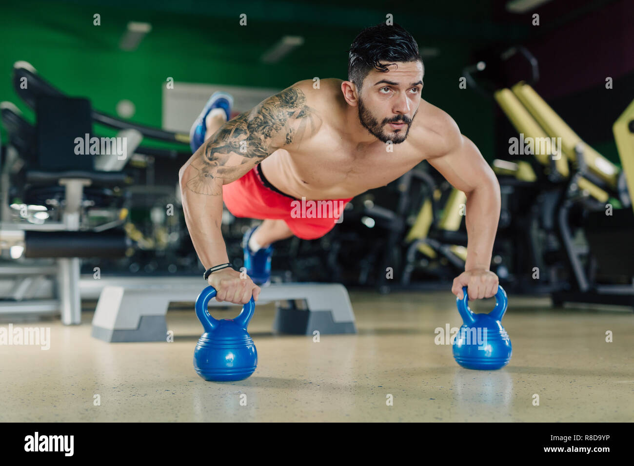 Strong man in the gym doing pushups Stock Photo - Alamy