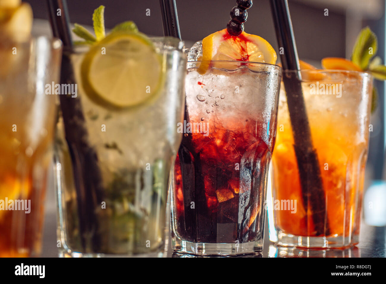 https://c8.alamy.com/comp/R8DGTJ/drink-here-cocktail-drinks-served-in-glasses-with-drinking-straws-alcoholic-mixed-drinks-with-ice-iced-drinks-in-cocktail-glasses-in-bar-juicy-beverages-with-alcohol-on-counter-alcohol-addiction-R8DGTJ.jpg