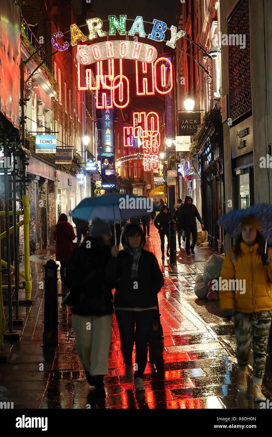 Couple with umbrella in Soho near Carnaby Street Christmas lights by night 2018 Stock Photo