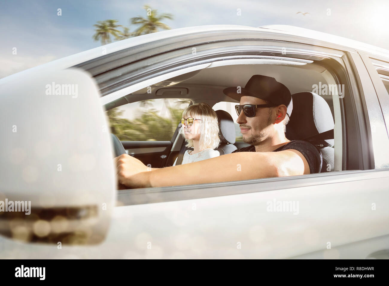 Young couple on summer vacation driving a car in a tropical location Stock Photo