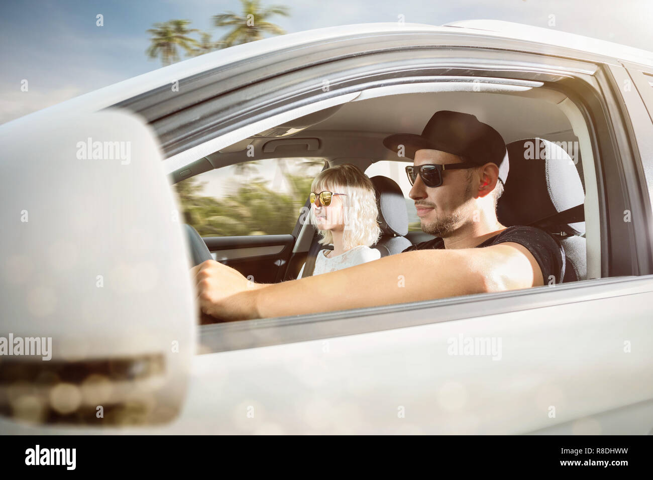 Young couple on summer vacation driving a car in a tropical location Stock Photo