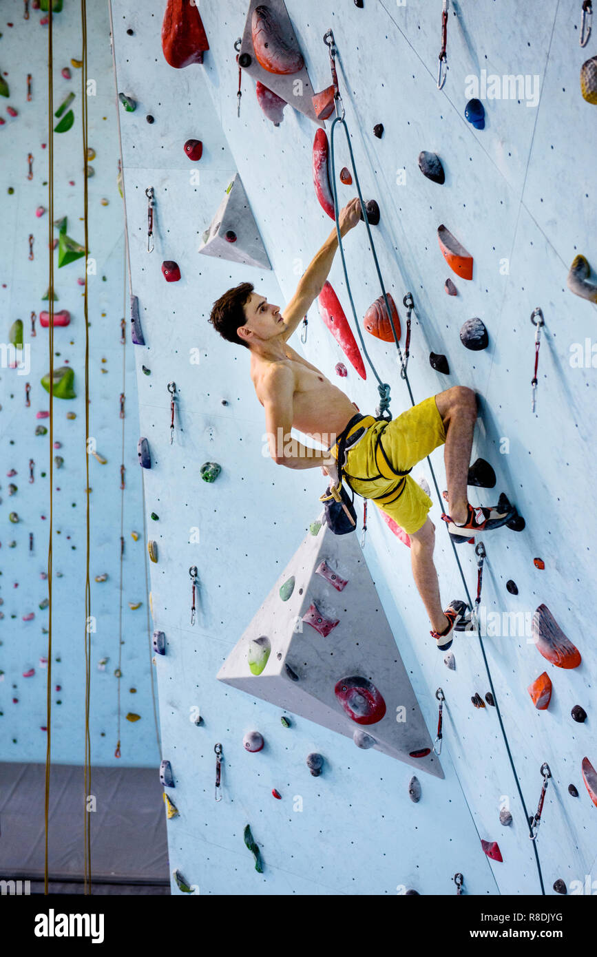 Climbing gym. Sport training. Strong athlete on a climbing wall