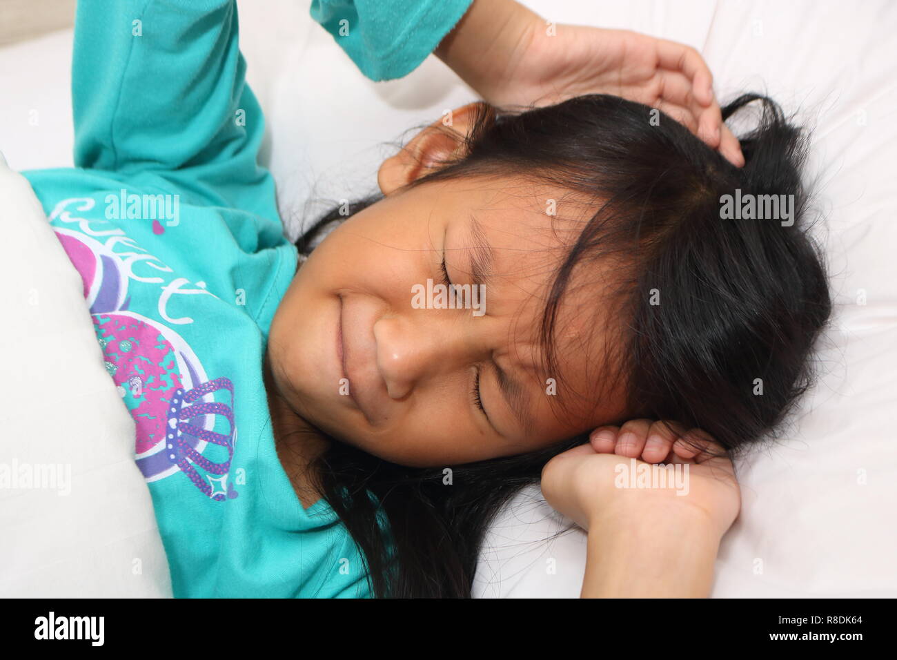 Little Asian girl having nightmare while sleeping Stock Photo
