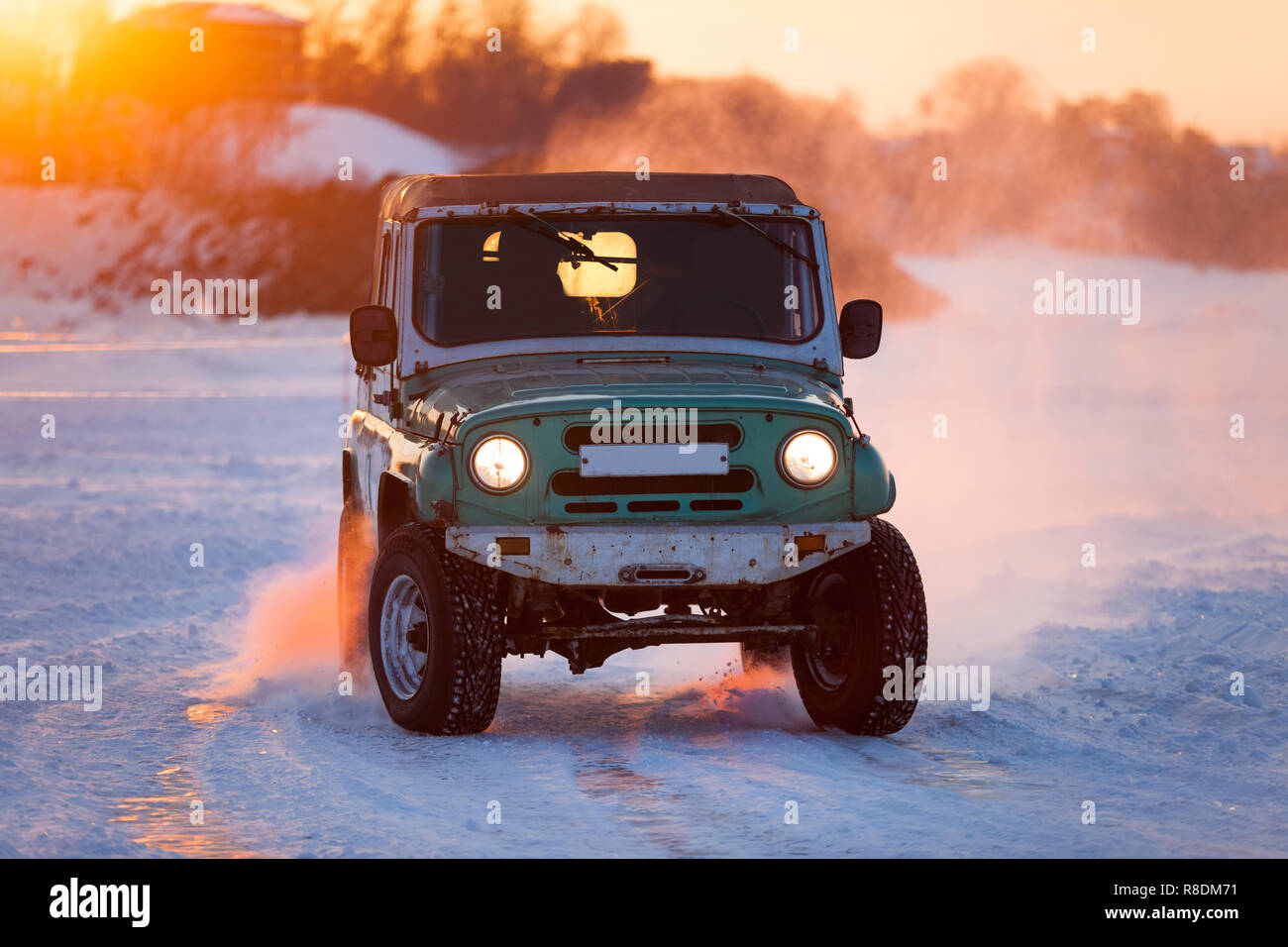 Russian UAZ 469 moving on ice of a frosn river at sunset Stock Photo